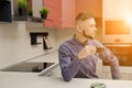 Man with coffee cup at the table in modern kitchen