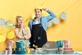 Man with colander on his head while his wife looking at