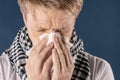 Man with cold and flu illness suffering from a headache and cough. Blue background Royalty Free Stock Photo