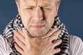 Man with cold and flu illness suffering from sore throat. Blue background Royalty Free Stock Photo