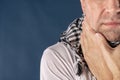 Man with cold and flu illness suffering from sore throat. Blue background Royalty Free Stock Photo