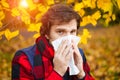 Man with cold rhinitis on autumn background. Fall flu season. Il Royalty Free Stock Photo