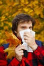 Man with cold rhinitis on autumn background. Fall flu season. Il Royalty Free Stock Photo
