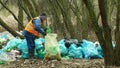 OLOMOUC, CZECH REPUBLIC, JANUARY 2, 2019: Man collect garbage rubbish gathers bag, forest landscape in endangered nature