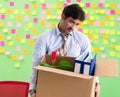 Man collecting his stuff after redundancy in the office with man