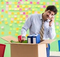 Man collecting his stuff after redundancy in the office with man