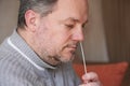man collecting nasal mucus sample from nose with cotton swab for covid-19 coronavirus self testing at home