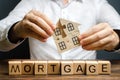 A man collects a house from the puzzles over the inscription Mortgage. Construction of your own residential building. Buying