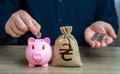 A man collects Ukrainian hryvnias in a piggy bank.