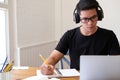 Man college student studying learning lesson with computer online taking note
