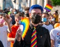 Man with a colored rainbow tie and a folding fan at LGBTQ Pride parade rally in Bucharest