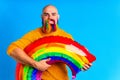 man with colorful beard holding big rainbow balloon in bludio background