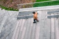 The man comes down the stairs. Concrete staircase with railings and green grass. Urban interior. View from above