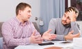 Man comforting upset friend at home table