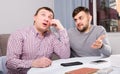 Man comforting upset friend at home table Royalty Free Stock Photo