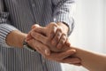 Man comforting woman on light background, closeup of hands.