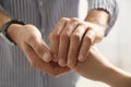 Man comforting woman on light background, closeup of hands. Royalty Free Stock Photo