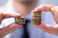 Man Comparing Two Coin Stacks Royalty Free Stock Photo