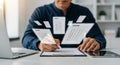 Man completing an exam on a clipboard with floating exam papers in a bright office setting at a desk Royalty Free Stock Photo