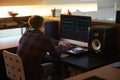 Man Composing Music on Computer in Bedroom