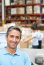 Man At Computer Terminal In Distribution Warehouse