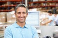 Man At Computer Terminal In Distribution Warehouse