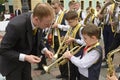 Man conductor from children brass orchestra helping little boy trumpeter to remember his party. Festival of brass Royalty Free Stock Photo