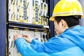 Man connecting network cables to switches in the computer room Royalty Free Stock Photo