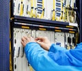 Man connecting network cables to switches in the computer room Royalty Free Stock Photo