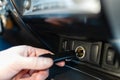 A man connects the device to the cigarette lighter of the car. T Royalty Free Stock Photo