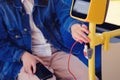 A man connects a phone wire on the bus. Mobile phone charger with usb in public transport and stop button Royalty Free Stock Photo
