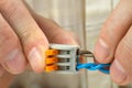 Man connects the twisted ends of the wires using compact splicing connector