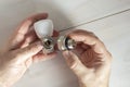 A man connects two parts of a heating radiator faucet.