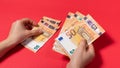 The man considers the money of the banknote 50 euros on a red background. Credit, money account, savings Royalty Free Stock Photo