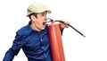 A man in a construction helmet on a white isolated background holds a fire extinguisher in his hands and shouts. The foreman. Royalty Free Stock Photo
