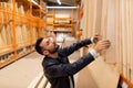 a man in a construction supermarket chooses plywood and boards for construction, housewarming concept and construction Royalty Free Stock Photo