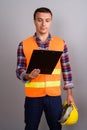 Man construction worker holding clipboard against gray backgroun Royalty Free Stock Photo