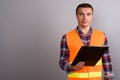 Man construction worker holding clipboard against gray backgroun Royalty Free Stock Photo