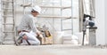 Man construction worker work with tool box wear gloves, hard hat and protection glasses at interior building site with scaffolding Royalty Free Stock Photo