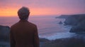 Man contemplates sunset over rugged coastline Royalty Free Stock Photo