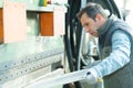 man controlling hydraulic press machine for cutting steel