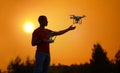 Man controls a quadrocopter. Warm sunset photo