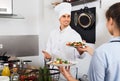 Man cook giving to waitress ready to serve salad Royalty Free Stock Photo