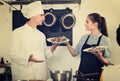 Man cook giving to waitress ready to serve salad Royalty Free Stock Photo