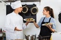 Man cook giving to waitress ready to serve salad Royalty Free Stock Photo
