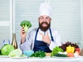 Man cook hat and apron hold broccoli. Healthy nutrition concept. Bearded professional chef cooking healthy food. Healthy Royalty Free Stock Photo