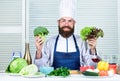 Man cook hat and apron hold broccoli. Organic vegetables. Healthy nutrition concept. Bearded professional chef cooking Royalty Free Stock Photo