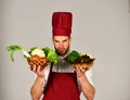 Man in cook hat and apron holds ingredients. Vegetarian meal