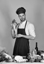 Man in cook hat and apron with radish. Cuisine and professional cooking concept. Cook works in kitchen Royalty Free Stock Photo