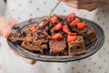 Closeup of man cook holding ready chocolate brownies Royalty Free Stock Photo